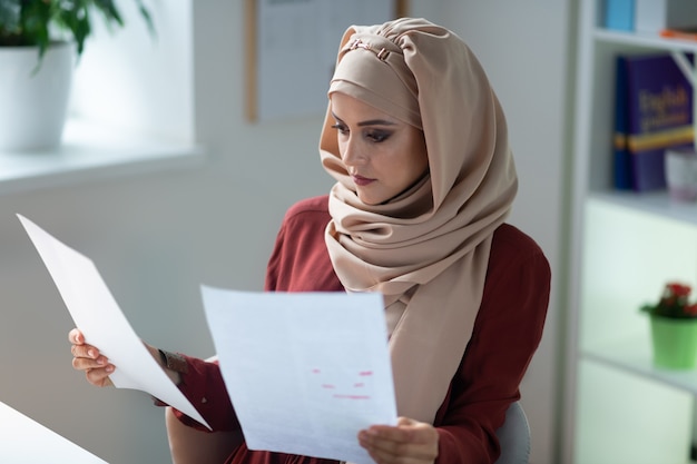 바쁜 선생님. 수업을 준비하는 동안 바쁜 느낌 hijab를 착용하는 젊은 무슬림 교사