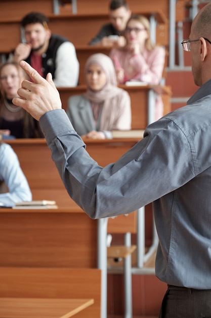 Foto insegnante che gesticola davanti a un gruppo di studenti durante la spiegazione