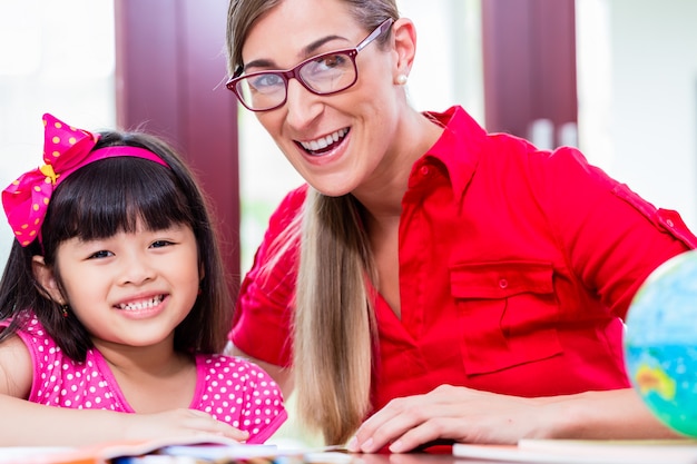 Teacher giving language lessons to Chinese child