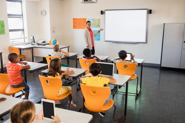 Teacher giving lesson to her students