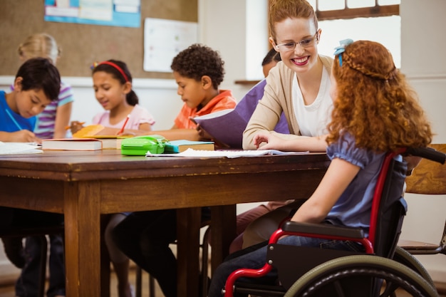 Photo teacher helping a disabled pupil