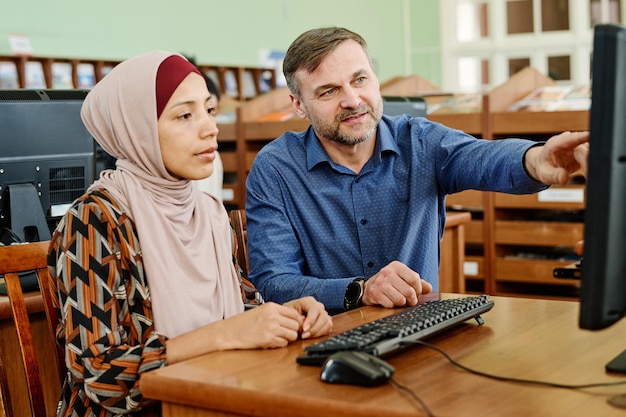 Teacher helping his female student