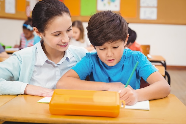 Teacher helping a little boy during class