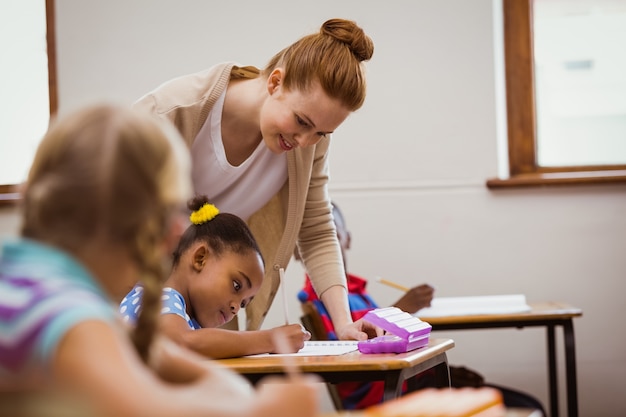 Teacher helping a little girl during class