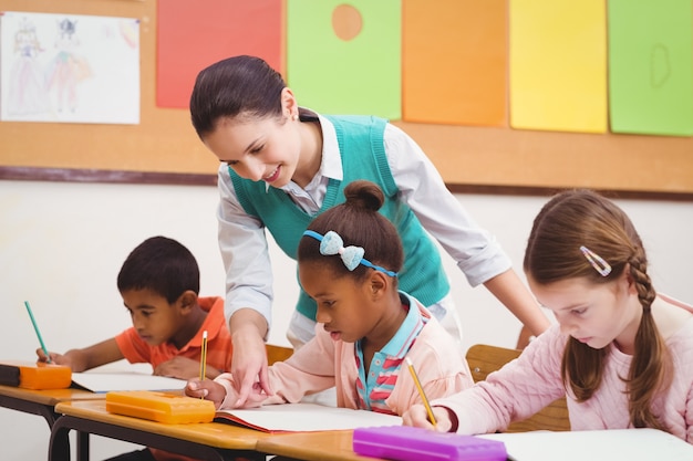 Teacher helping a little girl during class