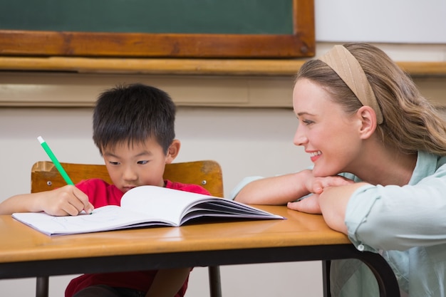 Teacher helping pupil in classroom 