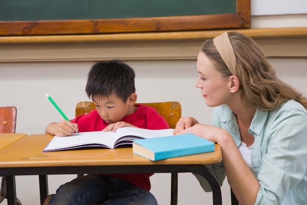 Teacher helping pupil in classroom 