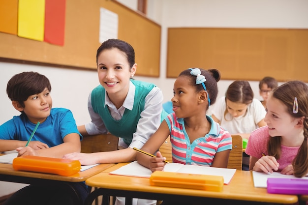 Teacher helping pupils during class