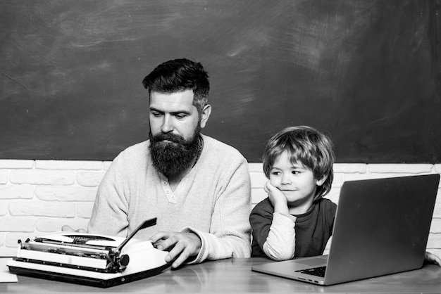 Teacher helping young boy with lesson chalkboard copy space elementary school teacher helping kids w...