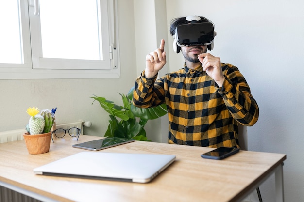 Учитель в классе домашнего офиса со своим компьютером и очками виртуальной реальности
