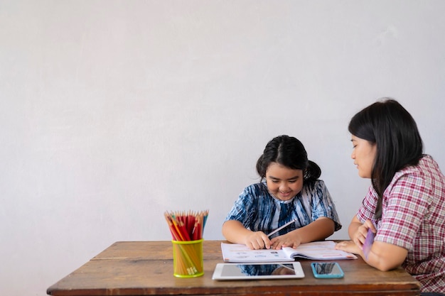 The teacher is teaching an Asian girl They are learning math Students are solving mathematical problems