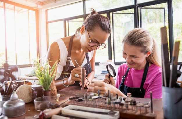 Teacher jeweler and student make jewelry in workshop