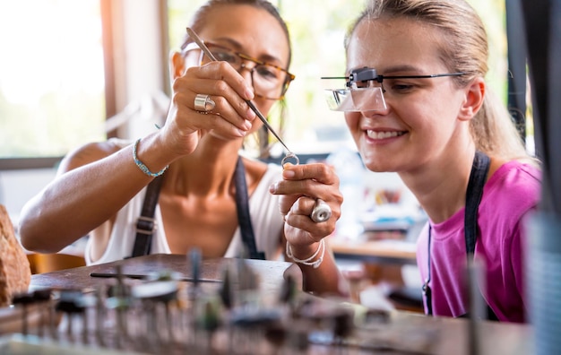 Teacher jeweler and student make jewelry in workshop