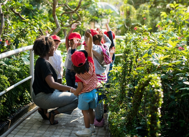 Scuola di insegnanti e bambini che imparano giardinaggio ecologico