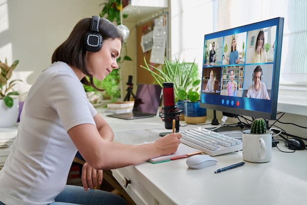 10代の生徒のグループとPC画面のオンラインレッスンを見ている教師