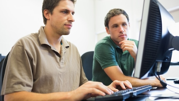 Teacher and mature student in computer room