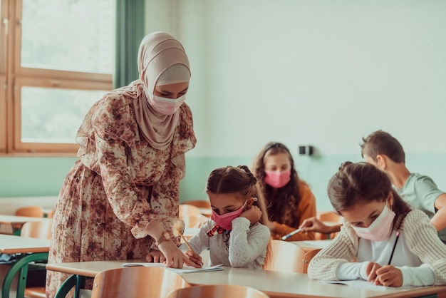 Teacher in medical mask pointing with a finger near bored schoolgirlNew normal Education during the Covid19 pandemic Selective focus High quality photo