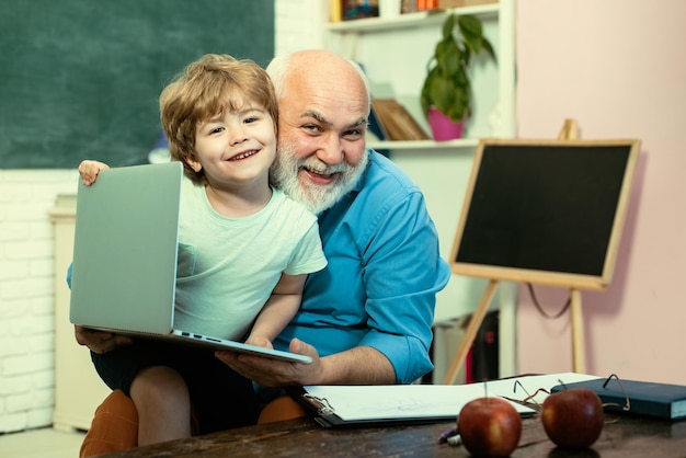 Teacher and pupil learning together in school grandfather and grandson father and son