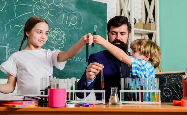 教師と生徒が教室で試験管化学をテーマにしたクラブ物質の特性を一緒に発見して探求する子供たちは科学学校のクラブ教育などのクラブの分野で成長することができます