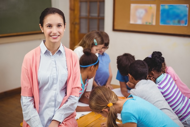 Teacher and pupils working at desk together