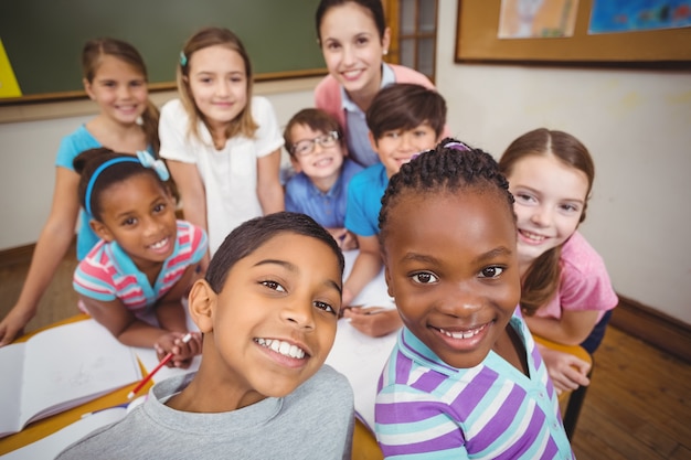 Teacher and pupils working at desk together