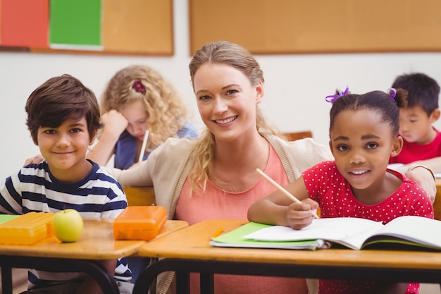 Teacher and pupils working at desk together