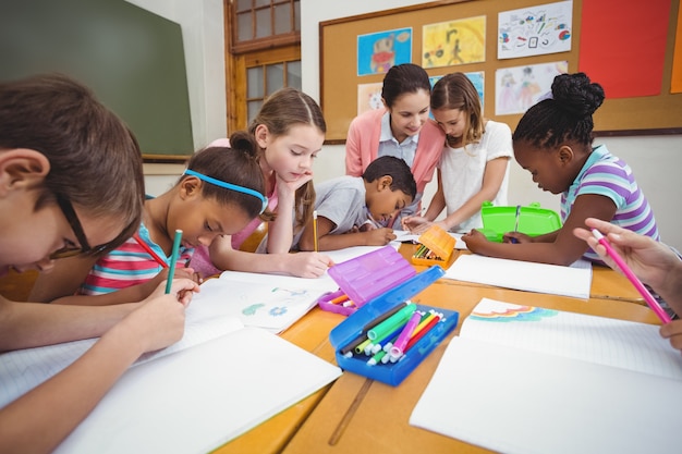 Teacher and pupils working at desk together