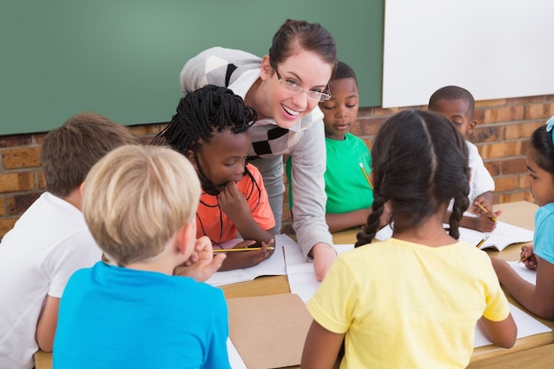 Teacher and pupils working at desk together