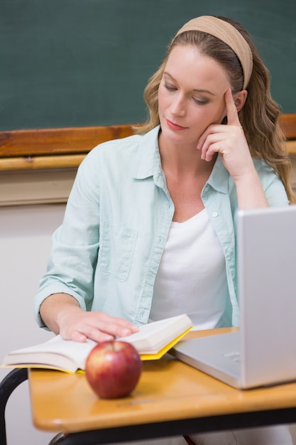 Teacher reading book at her desk 