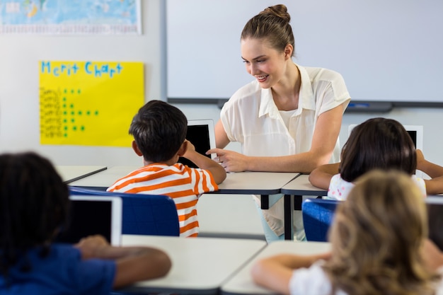 Teacher showing digital tablet to boy