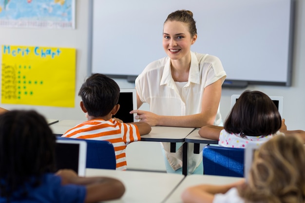 Teacher showing digital tablet with children