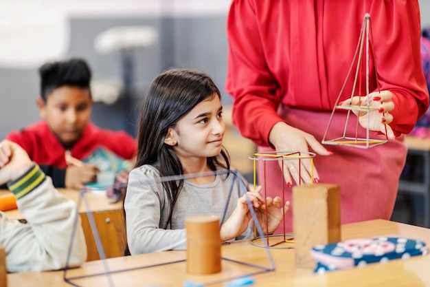 A teacher showing geometry to a pupil in classroom