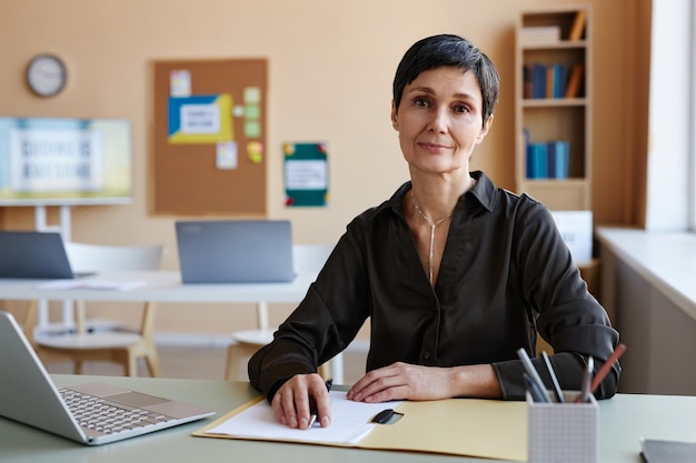 Teacher sitting at her workplace with laptop