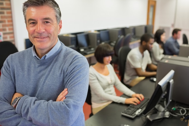 Teacher smiling at top of computer class