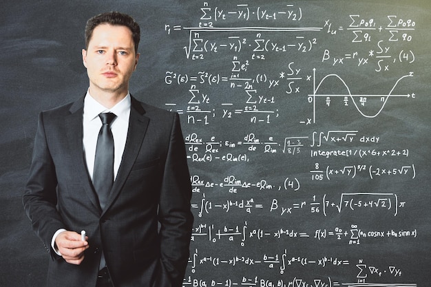 The teacher stands in front of the school blackboard on which is written solution