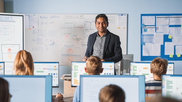 A teacher stands in front of a whiteboard that says'a'on it '