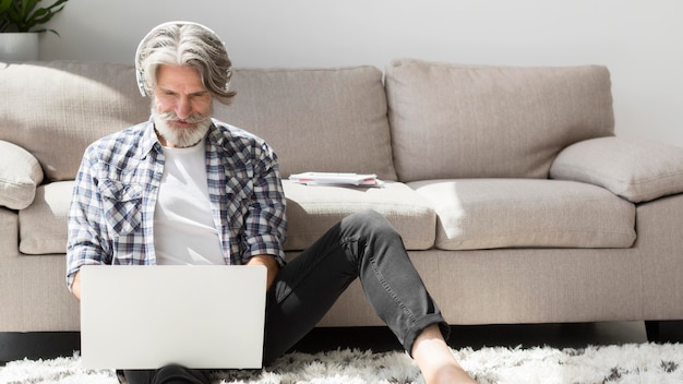 Photo teacher staying on floor looking at laptop