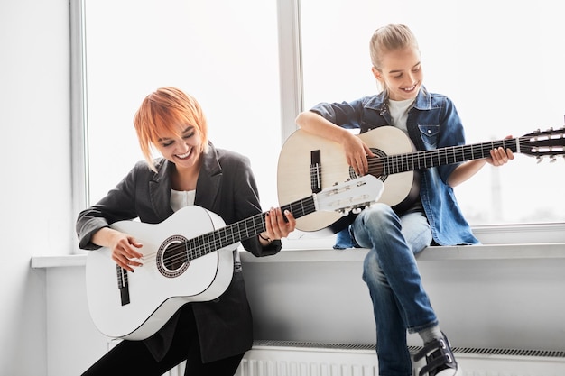 Teacher and student playing guitars