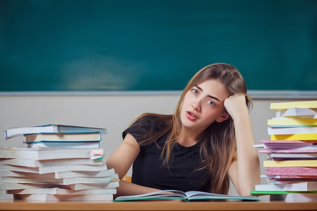 Teacher surrounded by books in a school classroom