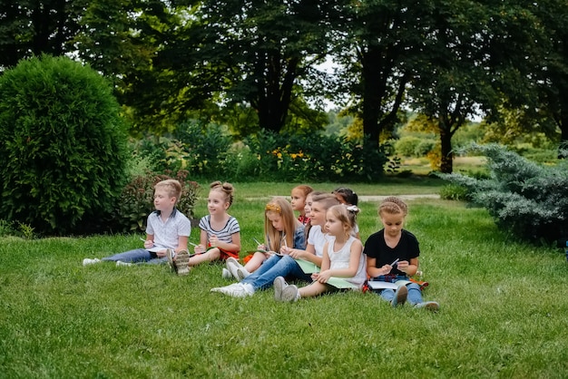 L'insegnante insegna a una classe di bambini in un parco all'aperto