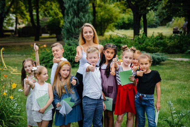 A teacher teaches a class of children in an outdoor Park