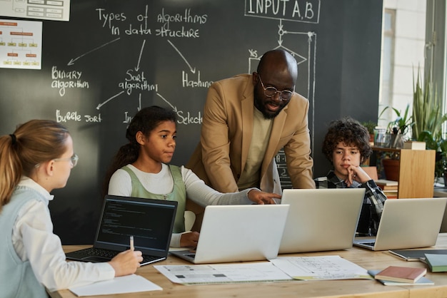 Teacher teaching students to use computers