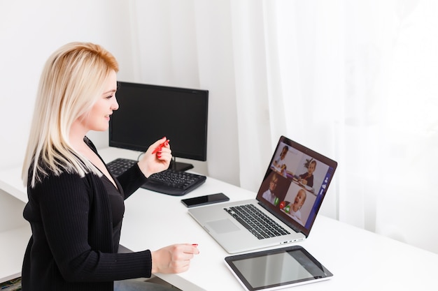 Teacher, tutor or professor with headset, laptop and camera in\
her office explaining something at an online lesson or video\
lecture, webinar