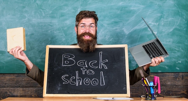 Teacher welcomes new pupils enter educational institution\
private school advertising to boost enrollments teacher or school\
principal welcomes with blackboard inscription back to school come\
to us