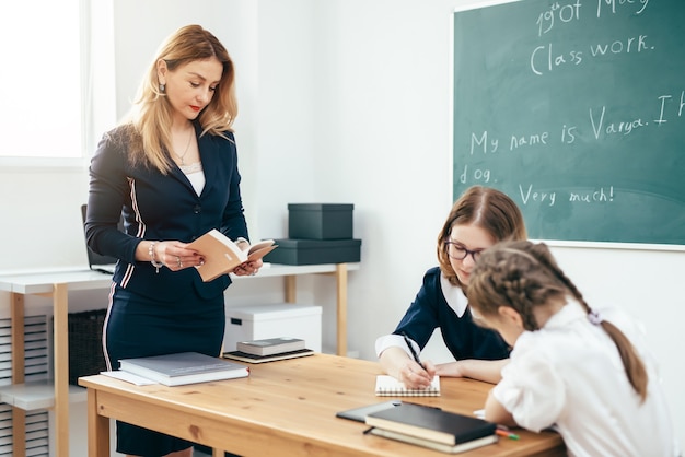 Teacher with book giving lesson in classroom.