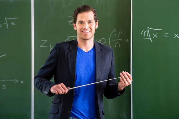 Teacher with pointer in front of a school class