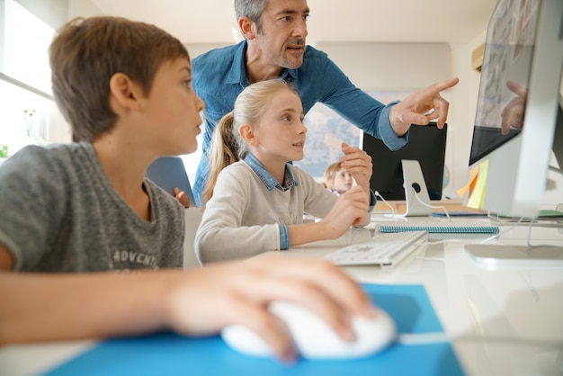 Foto insegnante con gli studenti in una classe di computer