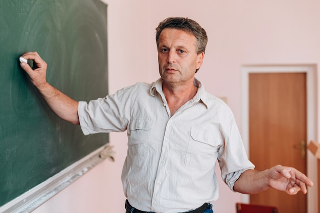 Teacher write on the blackboard and explain a lesson.