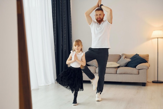 Teaching how to dance Father with his little daughter is at home together