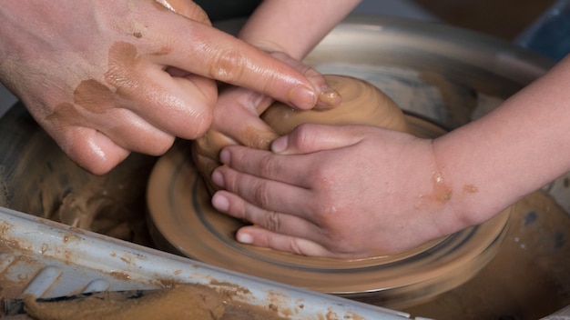 Teaching pottery to children. The teacher gives a master class in modeling